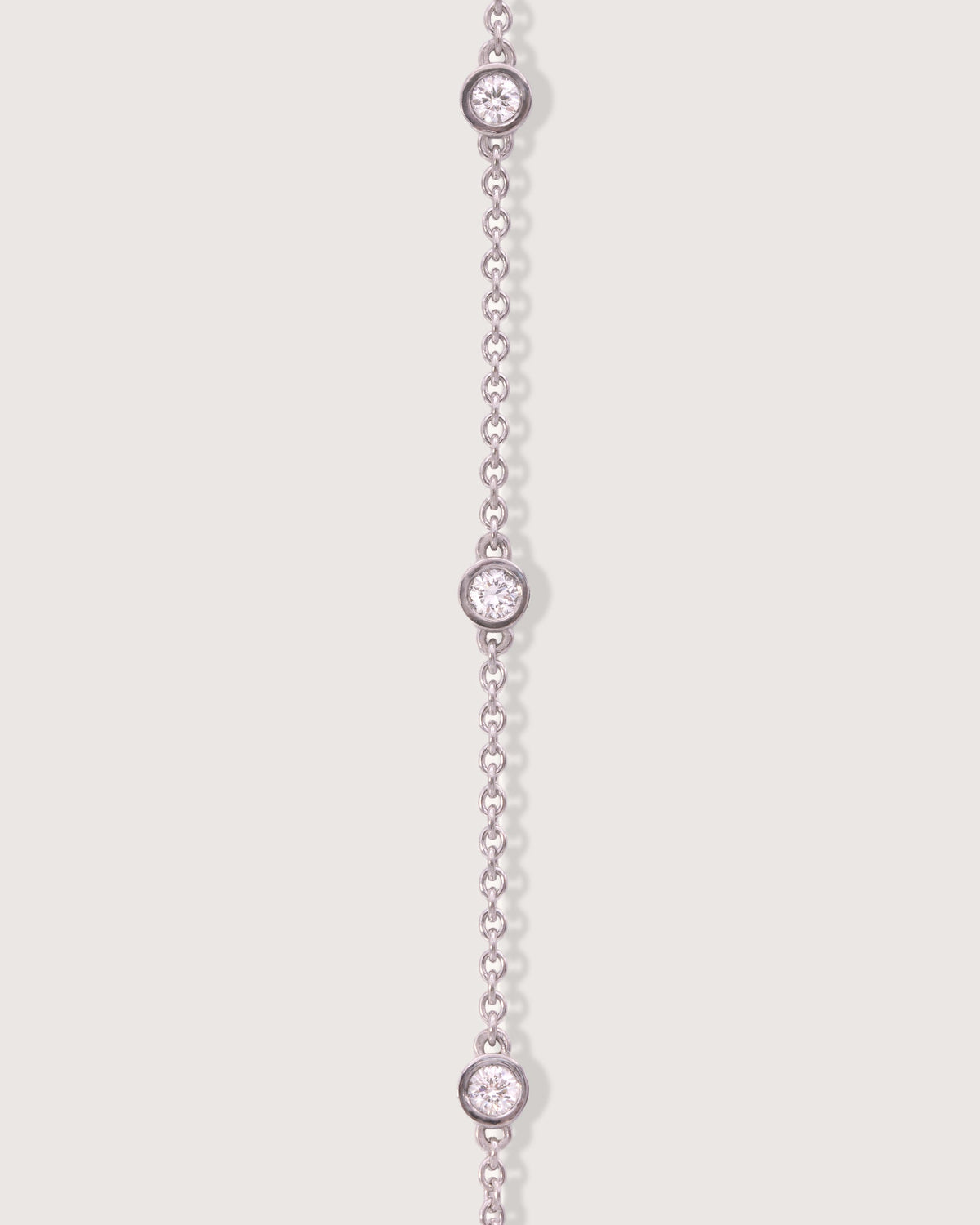 The Bezel Diamond Station Bracelet in recycled solid 18K white gold, set with five bezel-set diamonds.