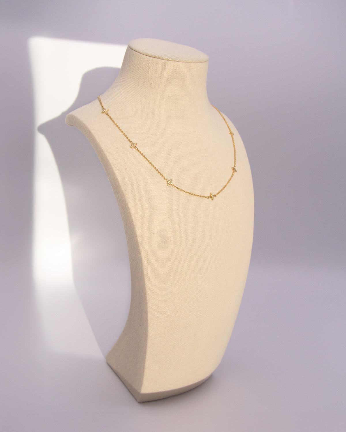The Flora Station Necklace in recycled solid 18K gold, set with five Flora motifs along the chain.
