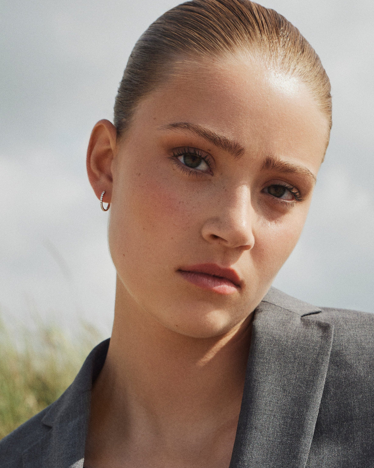 Model wearing the Medium Diamond Hoop earring in recycled 14K gold, set with 11 lab-grown diamonds in a click-closure design