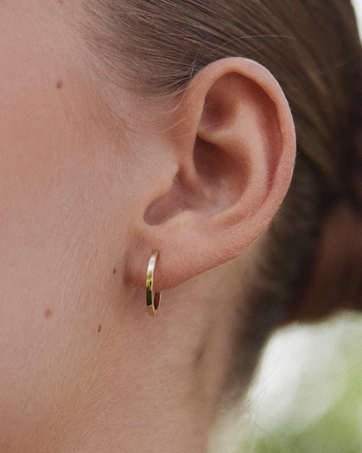 Close-up of ear with Medium Hoop earring in 14K gold.