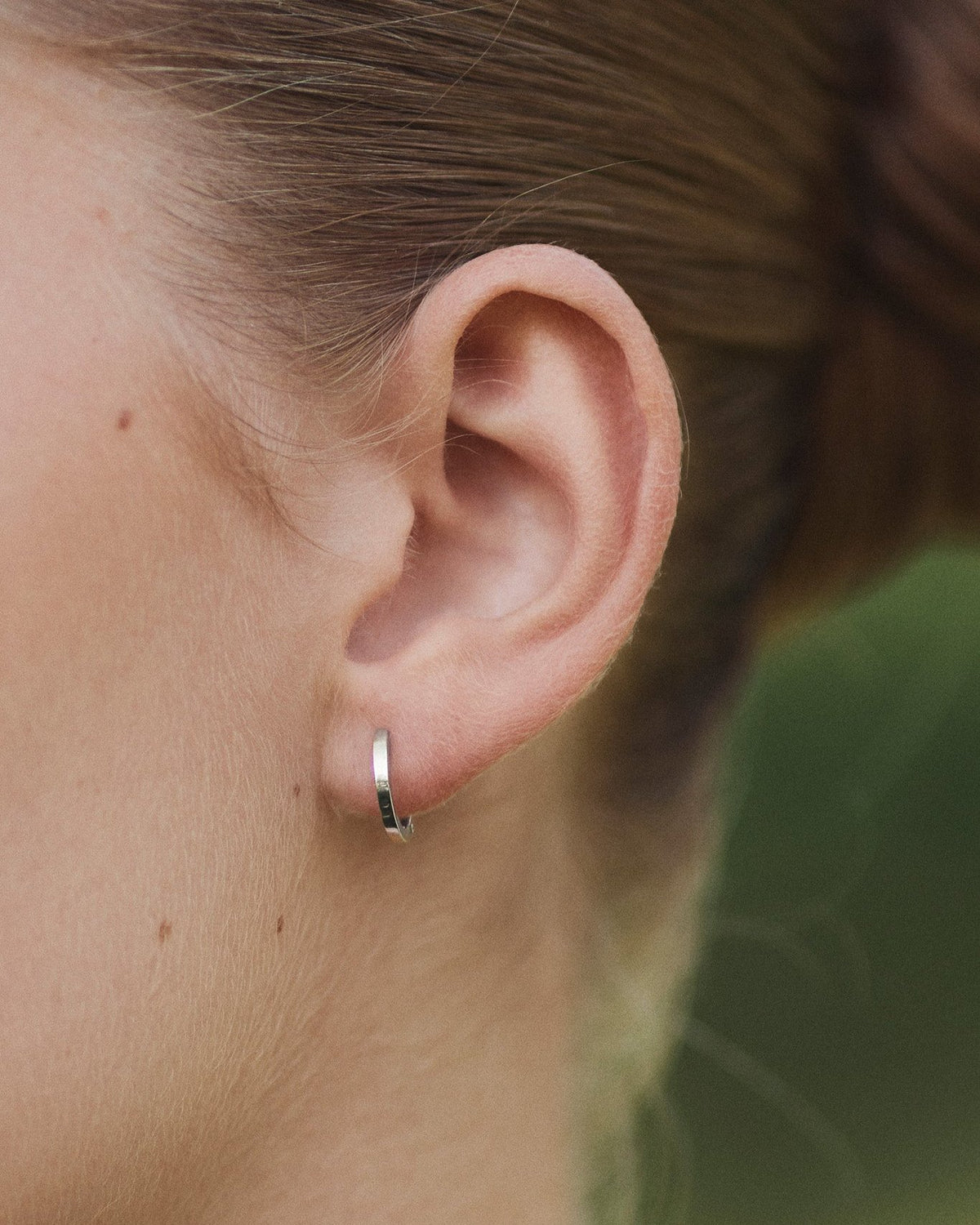 Close-up of ear with Small Hoop earring in 14K white gold.