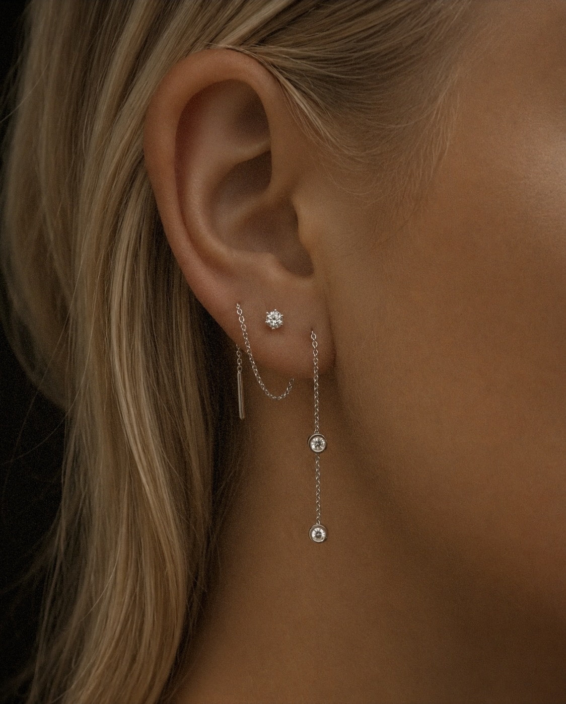 The Diamond Threader Earring in recycled 18K white gold, worn threaded through the ear.