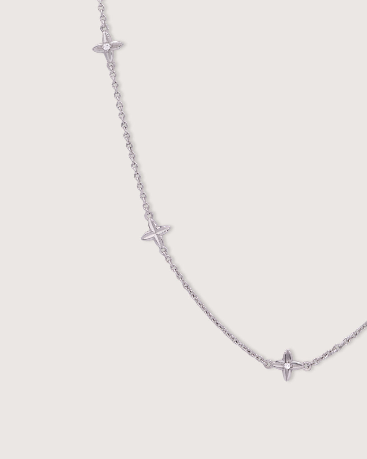 The Flora Station Necklace in recycled solid 18K white gold, set with five Flora motifs along the chain.