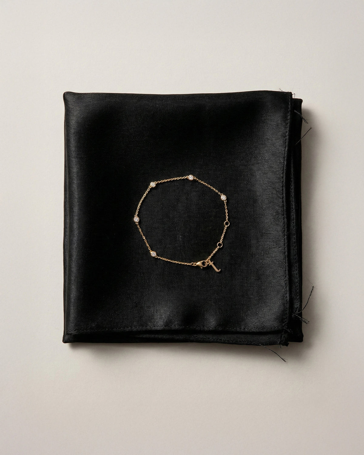 The Bezel Diamond Station Bracelet in recycled solid 18K gold, set with five bezel-set diamonds.