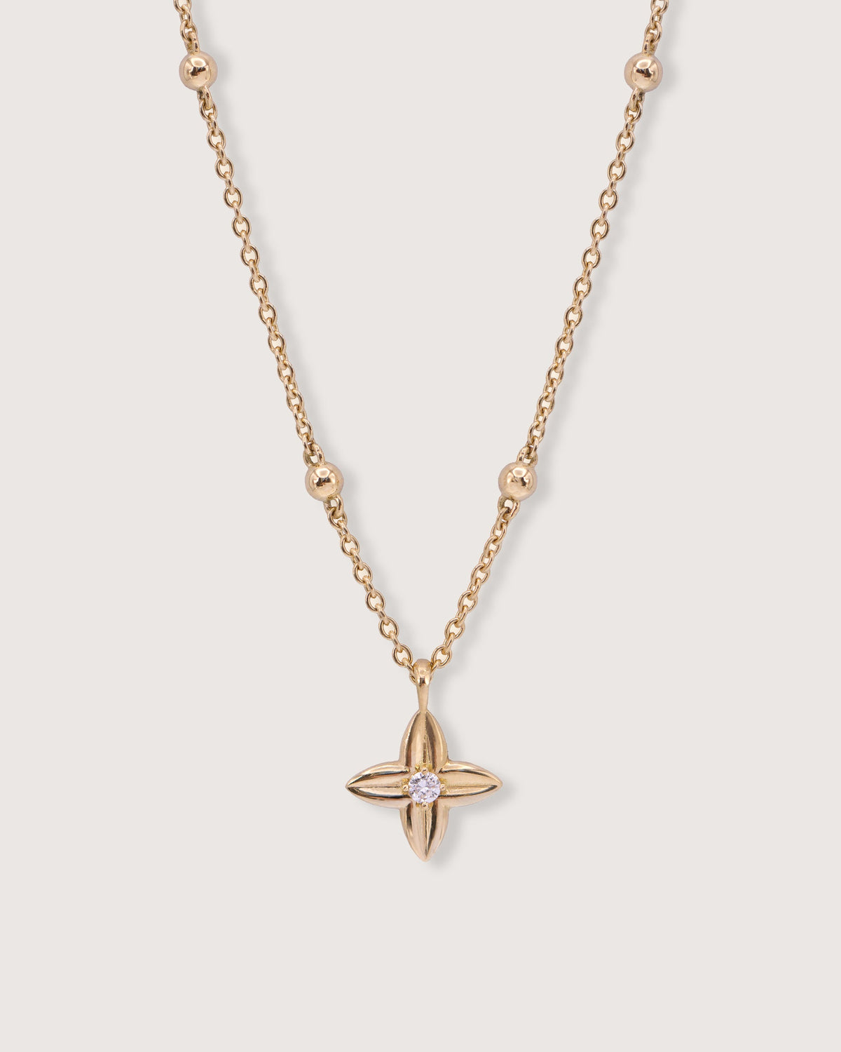 The Flora Necklace in recycled solid 18K gold, centered on the signature Flora charm with a lab-grown diamond.