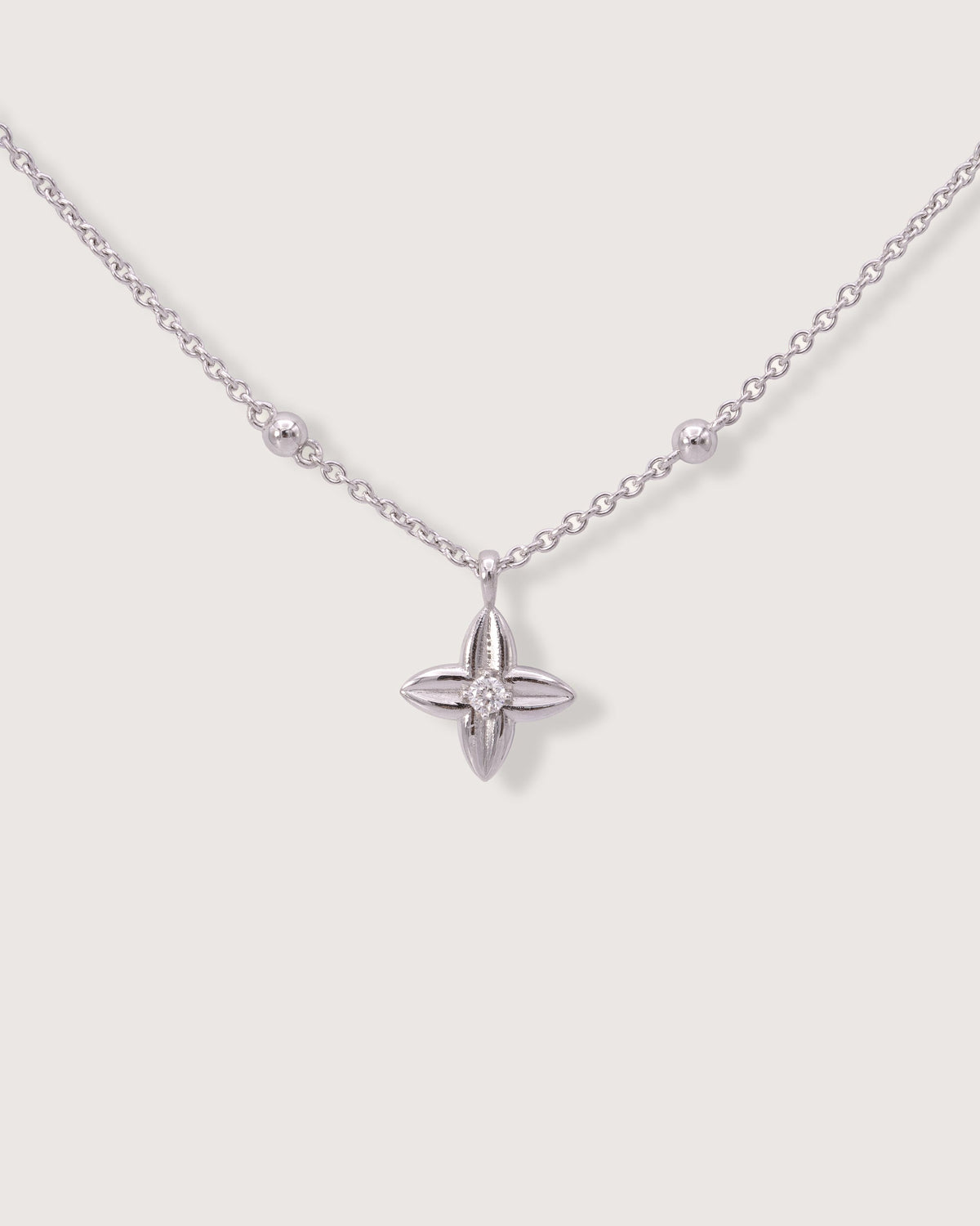 The Flora Necklace in recycled solid 18K white gold, centered on the signature Flora charm with a lab-grown diamond.