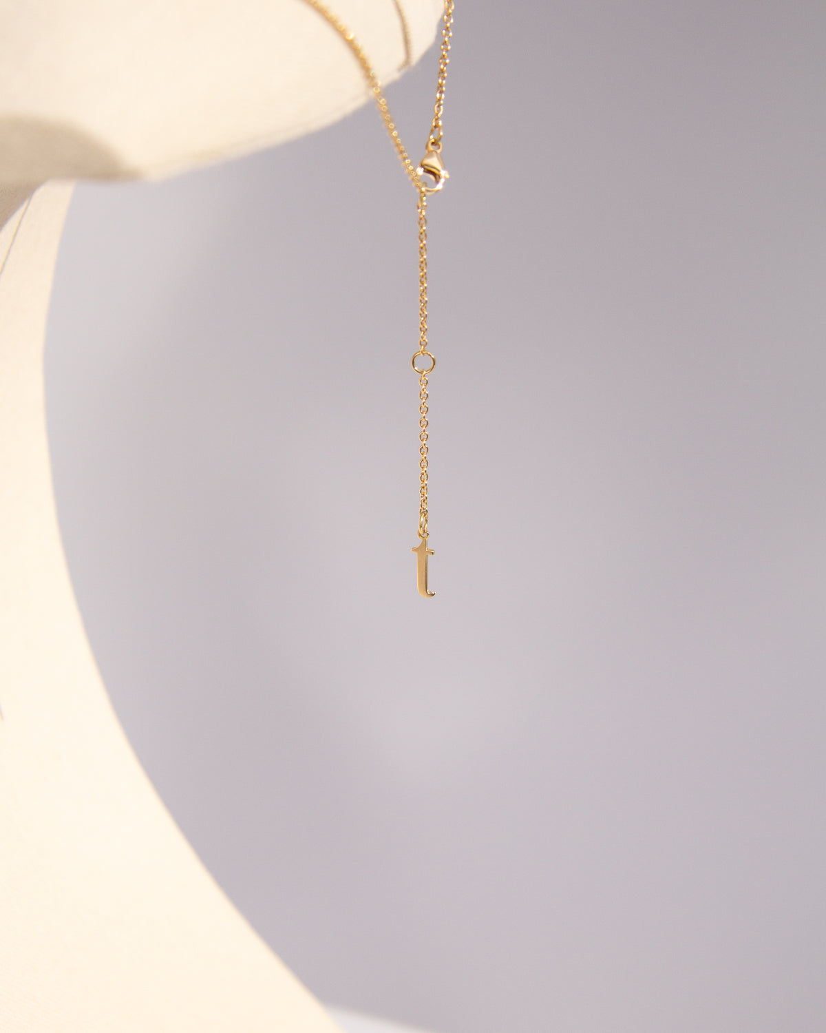 A TON TON necklace worn layered at the neckline, recycled 18K gold.