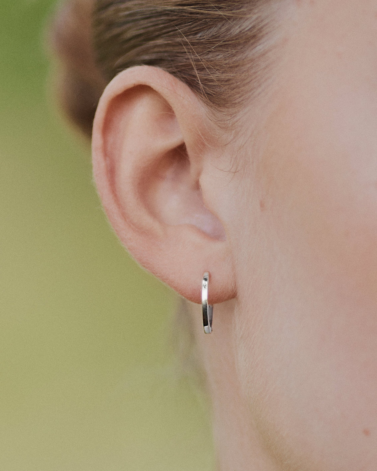 Close-up of ear with Medium Hoop earring in 14K white gold.